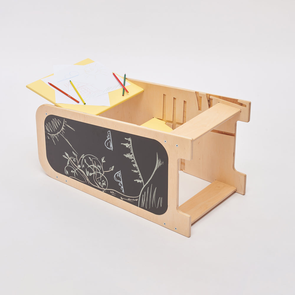 Montessori Lernturm aus Naturholz mit gelbem seitlichem Busy Board, ausgestattet mit interaktiven Zahnrädern, Schiebereglern und verschließbaren Elementen für Kleinkinder.
